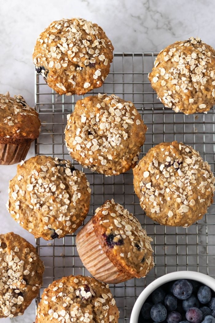 banana blueberry oatmeal muffins scattered on a cooling rack